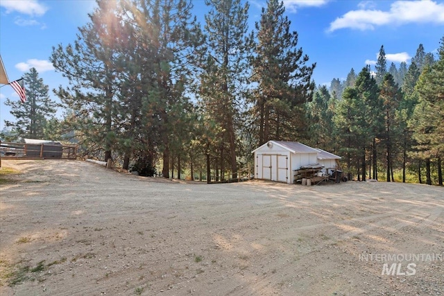 view of yard featuring fence, an outbuilding, and a storage unit