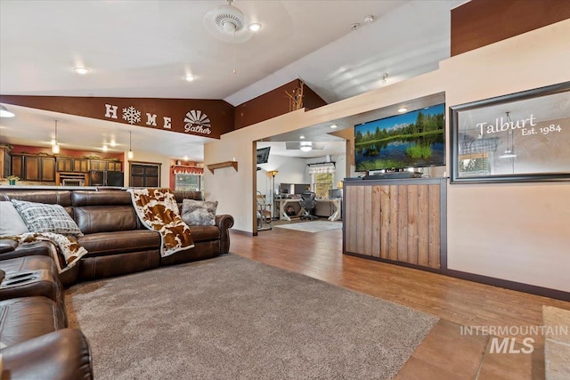 living room with lofted ceiling, wood finished floors, and baseboards