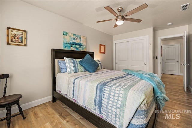 bedroom featuring baseboards, light wood finished floors, a closet, and a ceiling fan