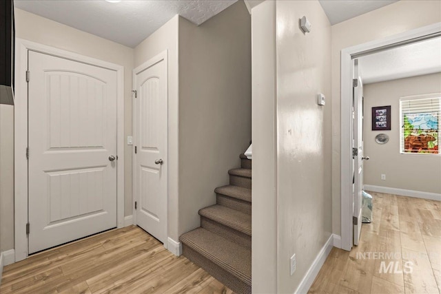 staircase with wood finished floors and baseboards