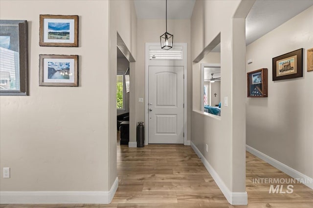 foyer entrance with light wood finished floors and baseboards