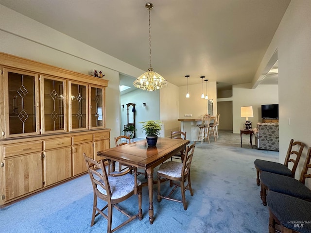 dining space with an inviting chandelier and light carpet