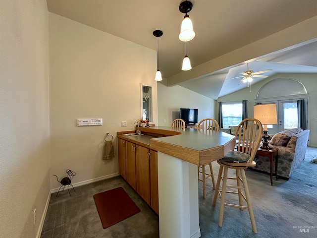 kitchen with brown cabinets, open floor plan, a peninsula, and carpet floors