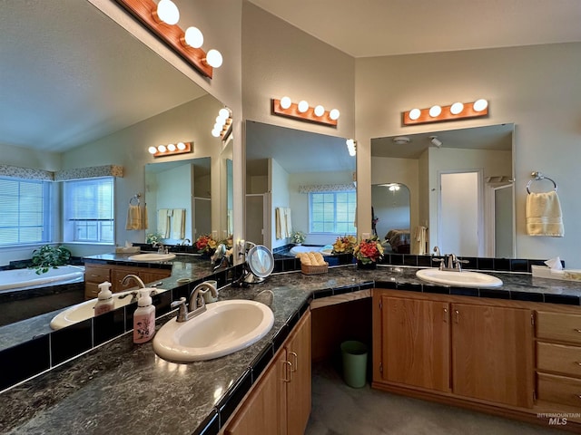 bathroom featuring a shower with door, vanity, lofted ceiling, and a healthy amount of sunlight