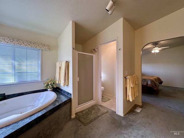 bathroom featuring a bath, a shower stall, toilet, and ceiling fan