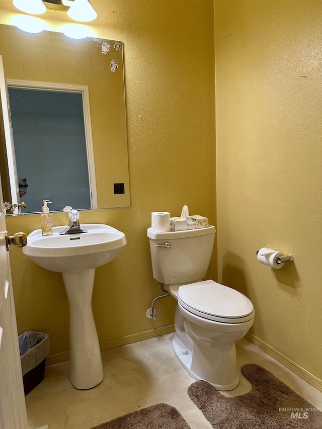bathroom with toilet and baseboards