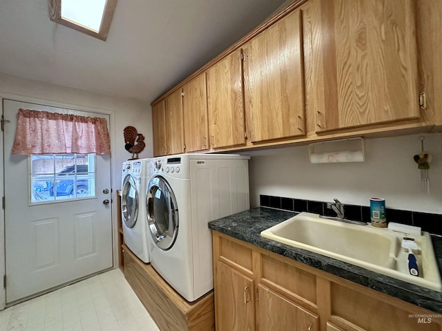 laundry area featuring cabinet space, washing machine and clothes dryer, and a sink