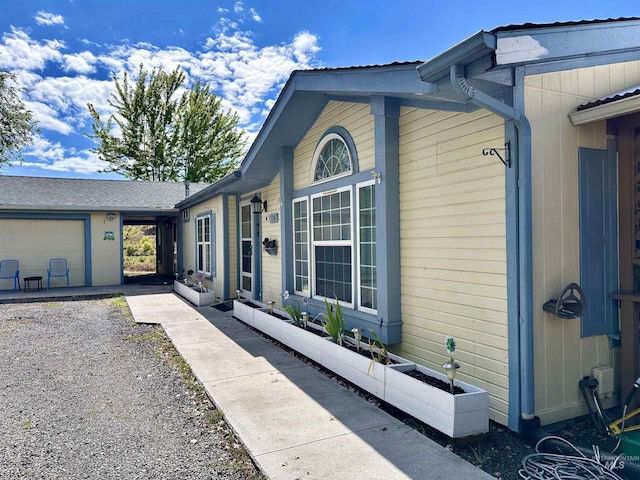 entrance to property featuring gravel driveway and a garage