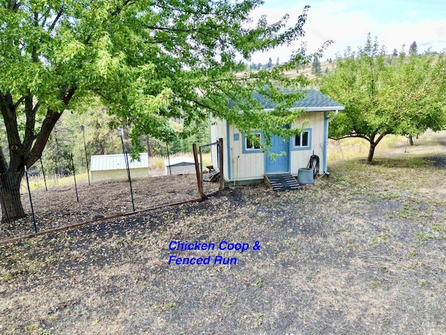 view of yard featuring fence and an outbuilding