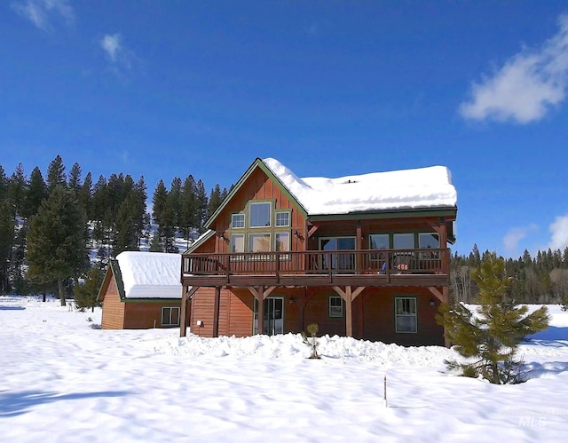 snow covered house with a deck