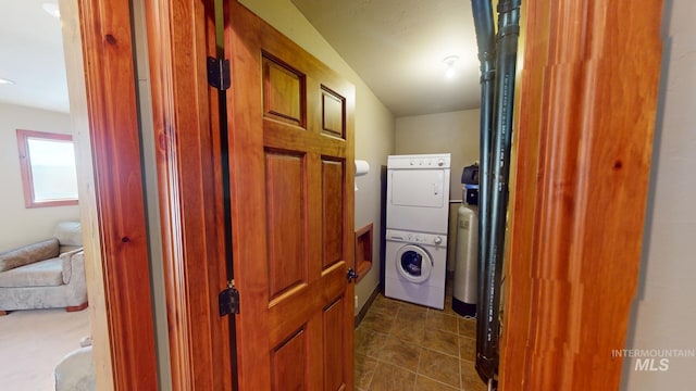 hallway with stacked washer and clothes dryer