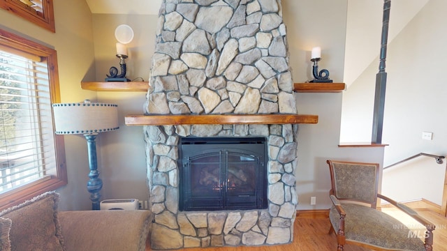 living room with a wealth of natural light, a fireplace, and light hardwood / wood-style floors