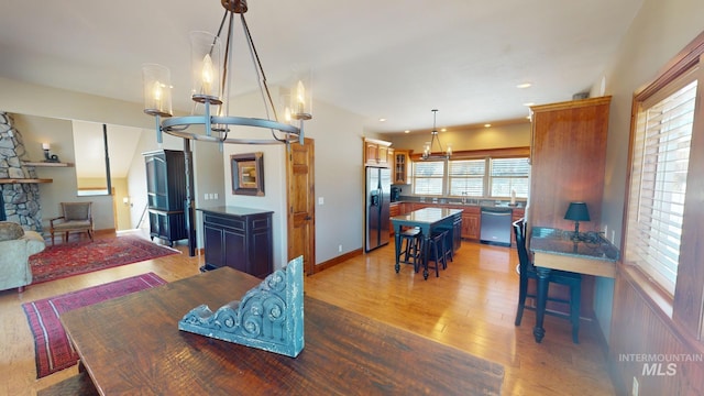 dining room featuring hardwood / wood-style floors, a fireplace, and an inviting chandelier