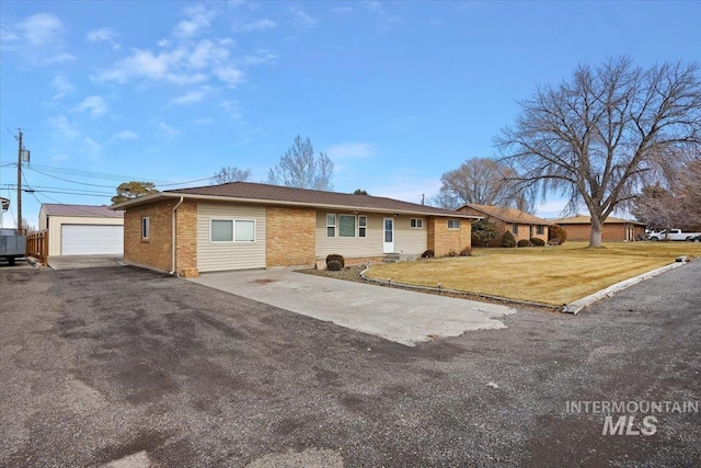 ranch-style home with a garage, brick siding, a front lawn, and an outdoor structure