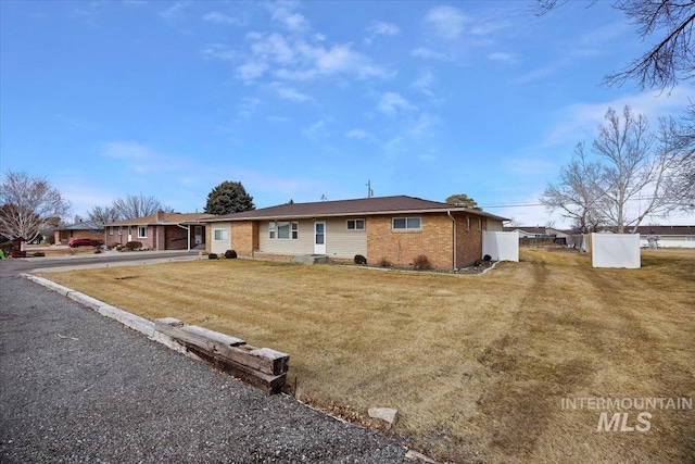 view of front of home featuring brick siding and a front lawn