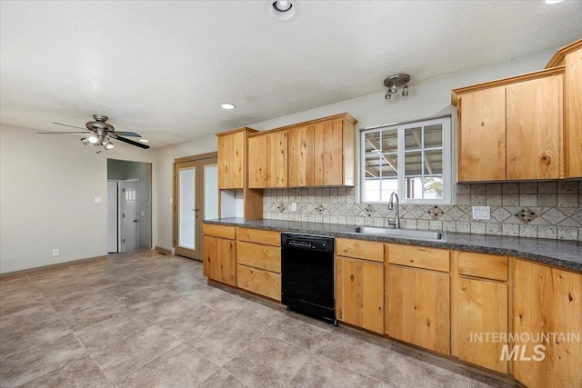 kitchen featuring dishwasher, tasteful backsplash, dark countertops, and a sink