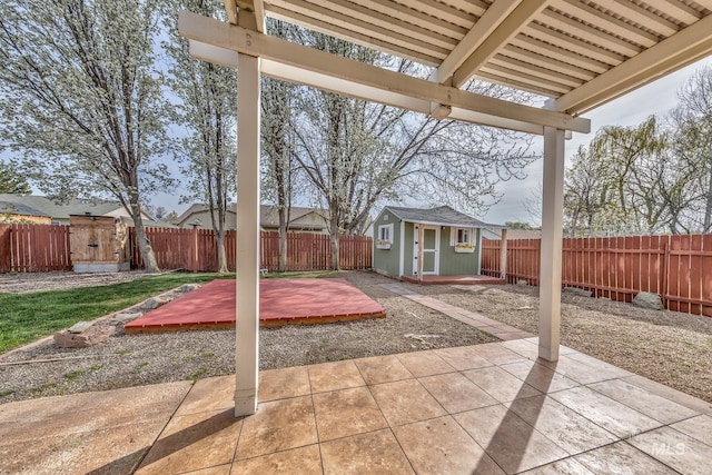 view of patio / terrace with a storage shed, a fenced backyard, and an outbuilding