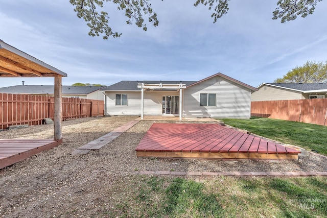 rear view of house with a yard, a fenced backyard, a pergola, and a deck