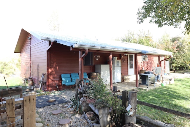 rear view of house with a lawn and a patio area