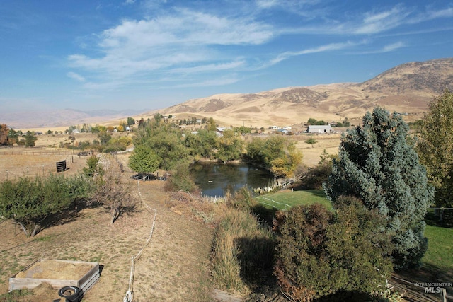 view of mountain feature featuring a water view and a rural view