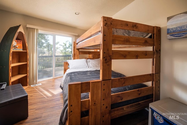 8600 W Brookside Ln, Boise, ID 83714 - bedroom with access to outside, a textured ceiling, visible vents, and wood finished floors