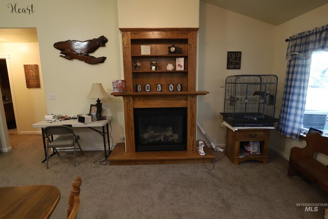 810 Pine St, Filer, ID 83328 - living room featuring a fireplace with raised hearth, carpet, vaulted ceiling, and baseboards