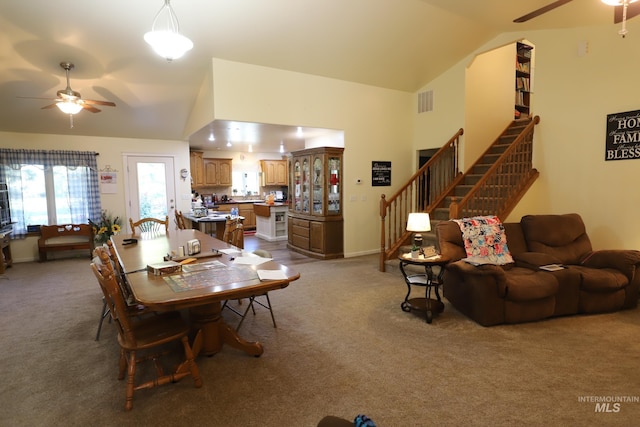 dining area featuring light colored carpet, vaulted ceiling, and ceiling fan