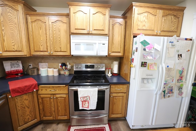810 Pine St, Filer, ID 83328 - kitchen featuring appliances with stainless steel finishes, dark countertops, tasteful backsplash, and dark wood-style flooring