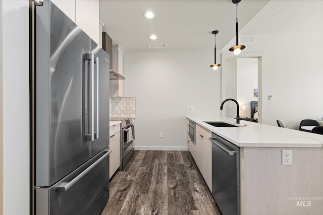 3928 E Haystack St Unit 2-208, Boise, ID 83716 - kitchen featuring appliances with stainless steel finishes, a peninsula, a sink, light countertops, and dark wood-style floors