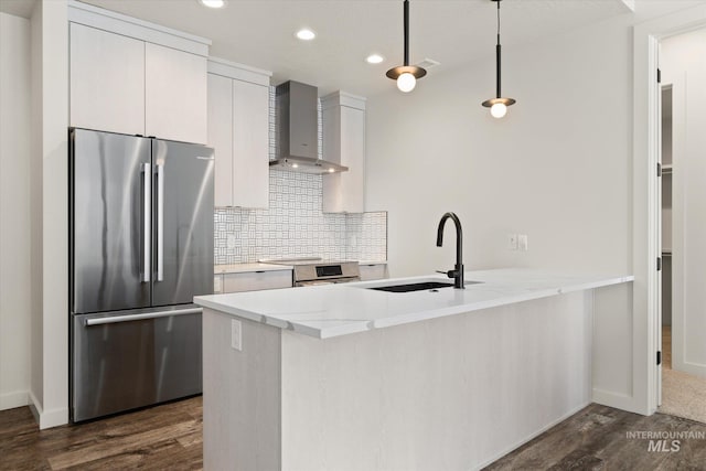 3928 E Haystack St Unit 2-208, Boise, ID 83716 - kitchen with stainless steel appliances, wall chimney range hood, a sink, a peninsula, and dark wood-type flooring