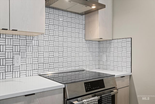 3928 E Haystack St Unit 2-208, Boise, ID 83716 - kitchen with stainless steel range with electric cooktop, decorative backsplash, extractor fan, and light countertops