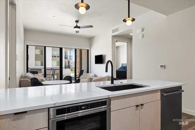 3928 E Haystack St Unit 2-208, Boise, ID 83716 - kitchen with oven, open floor plan, a sink, a textured ceiling, and light stone counters