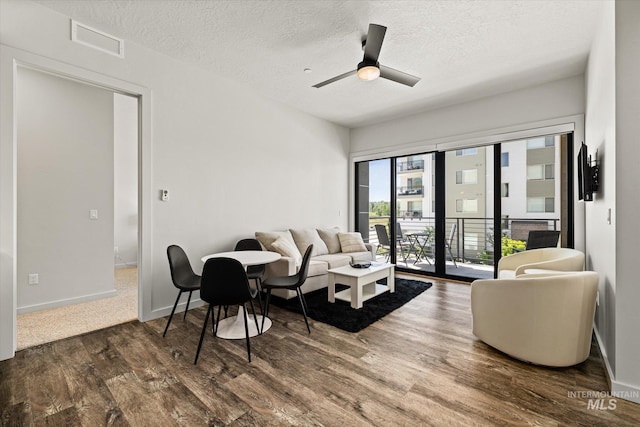 3928 E Haystack St Unit 2-208, Boise, ID 83716 - living room featuring wood finished floors, a textured ceiling, ceiling fan, and baseboards