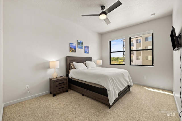 3928 E Haystack St Unit 2-208, Boise, ID 83716 - bedroom featuring light colored carpet, baseboards, a textured ceiling, and ceiling fan