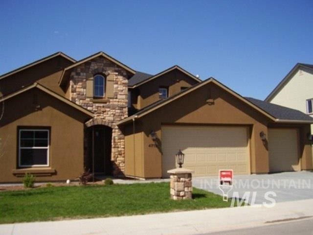 view of front of house featuring a garage, driveway, stone siding, and stucco siding