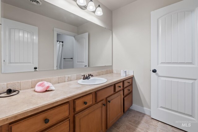 bathroom with visible vents, baseboards, and vanity