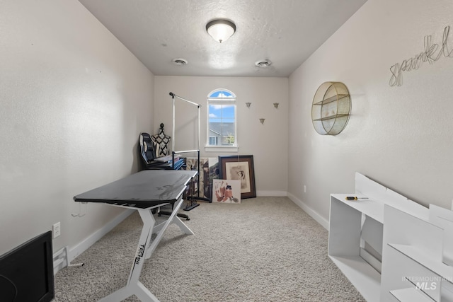home office featuring baseboards, a textured ceiling, and carpet