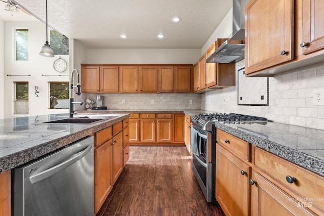 kitchen with dark wood-style flooring, wall chimney range hood, tile countertops, a sink, and appliances with stainless steel finishes