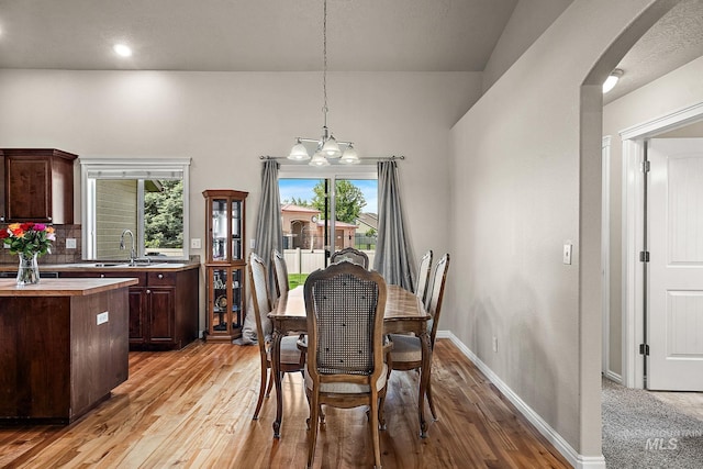 3401 S Murlo Way, Meridian, ID 83642 - dining room featuring light wood-style floors, a chandelier, baseboards, and arched walkways