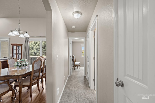3401 S Murlo Way, Meridian, ID 83642 - corridor with a chandelier, baseboards, arched walkways, a textured ceiling, and carpet floors