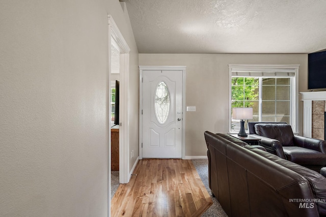 3401 S Murlo Way, Meridian, ID 83642 - entrance foyer with baseboards, light wood-type flooring, a textured ceiling, and a fireplace