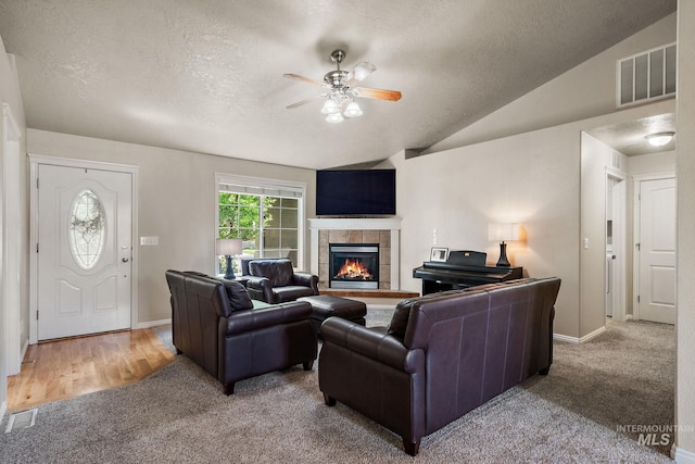 3401 S Murlo Way, Meridian, ID 83642 - carpeted living area with a textured ceiling, a tile fireplace, a ceiling fan, baseboards, and vaulted ceiling