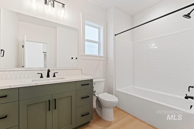 full bathroom with bathing tub / shower combination, wood-type flooring, vanity, tasteful backsplash, and toilet