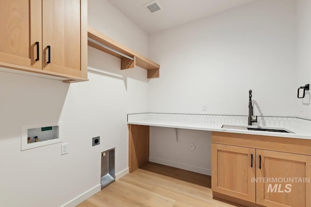 laundry area with sink, light wood-type flooring, washer hookup, electric dryer hookup, and cabinets