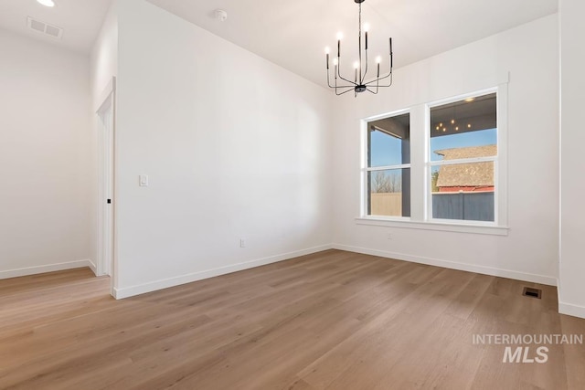 unfurnished dining area with a chandelier and wood-type flooring