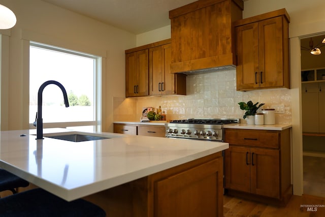1038 E Fleetwood Ct, Boise, ID 83706 - kitchen with a sink, decorative backsplash, brown cabinetry, light countertops, and range