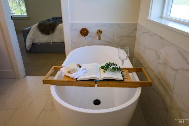 1038 E Fleetwood Ct, Boise, ID 83706 - ensuite bathroom featuring tile walls, ensuite bath, marble finish floor, and a freestanding bath