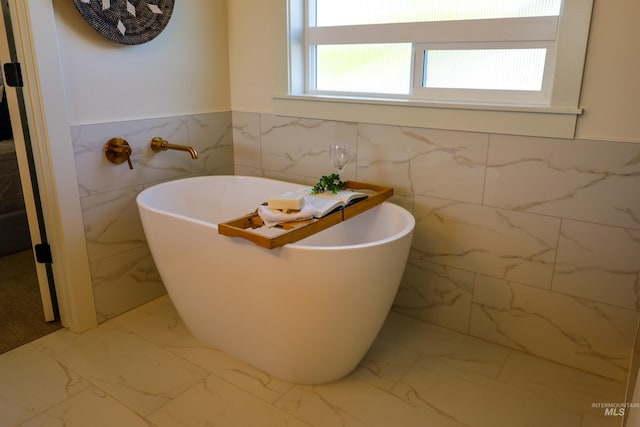 1038 E Fleetwood Ct, Boise, ID 83706 - bathroom with wainscoting, marble finish floor, a freestanding bath, and tile walls