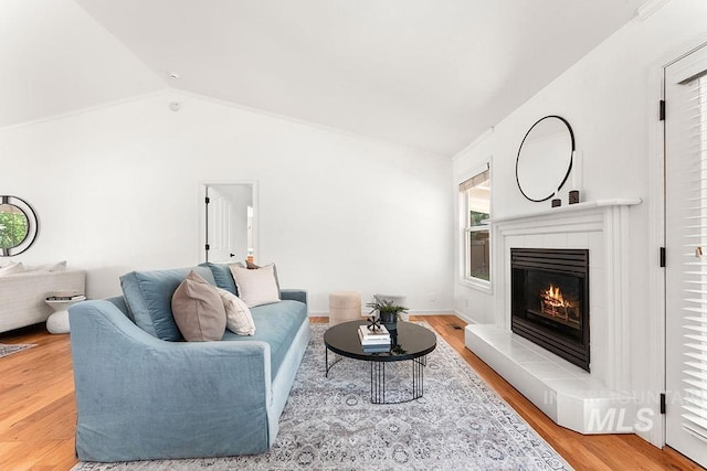1545 N Ellington Way, Eagle, ID 83616 - living room featuring plenty of natural light, a tiled fireplace, vaulted ceiling, and light wood finished floors