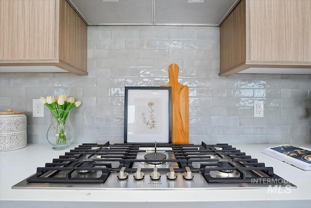 6200 S Binky Ave, Meridian, ID 83642 - kitchen view of stainless steel gas stovetop, decorative backsplash, light countertops, and light brown cabinetry